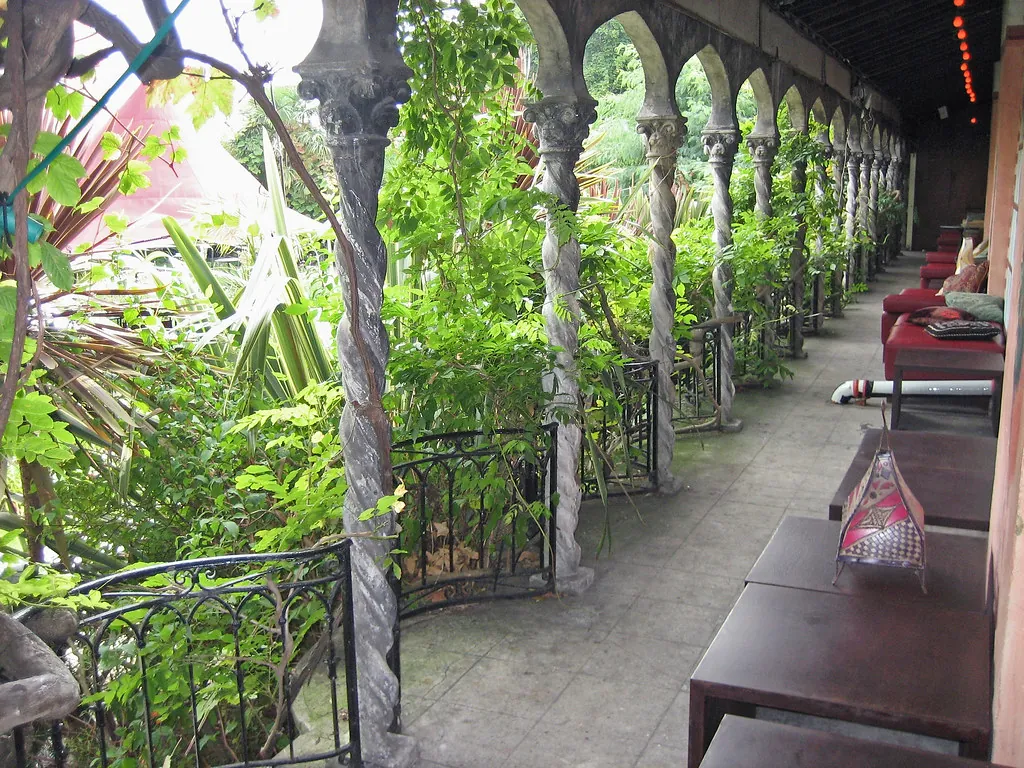 Corredor con mesas y plantas colgantes